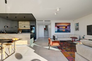 A modern living space with a kitchen, dining area, and a sofa in the living room. - Penthouse with ocean views and a private pool (Marbella)