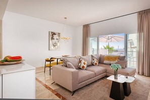 Ein modernes Wohnzimmer mit einer Couch, einem Esstisch und Blick ins Freie.