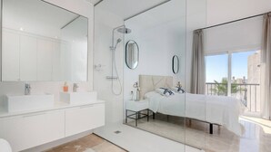 A modern bathroom with a glass shower enclosure, a large mirror, and a white vanity. - Luxury Family Penthouse, 7 Pools, Ocean View & Golf (Benahavís)