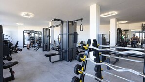 A modern gym with various exercise equipment, including weight machines and free weights. - Luxury Family Penthouse, 7 Pools, Ocean View & Golf (Benahavís)