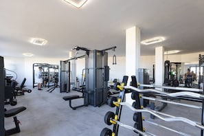 Ein modernes Fitnessstudio mit verschiedenen Trainingsgeräten, darunter Kraftgeräte und Kurzhanteln.
