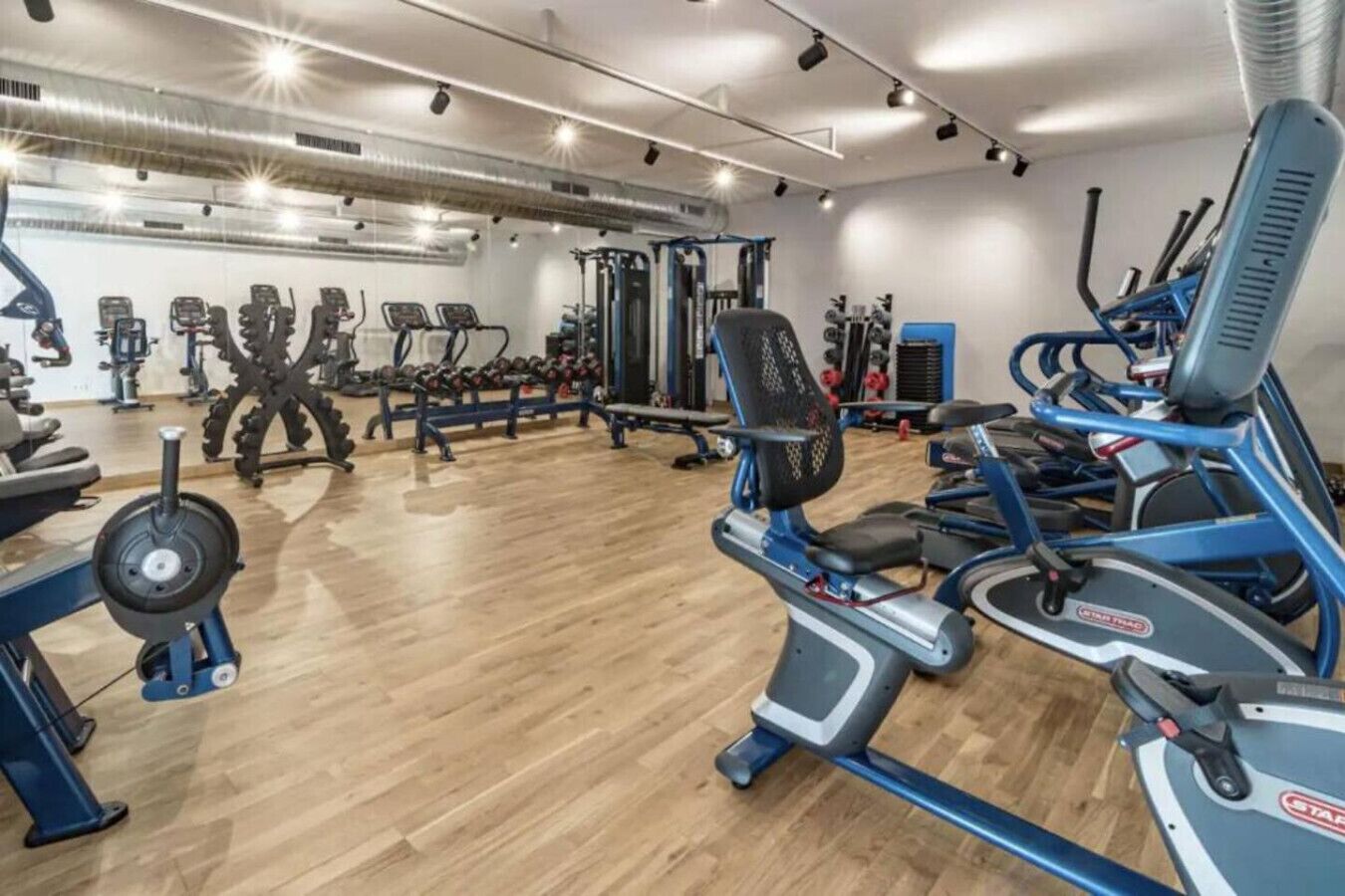 Et fitnesscenter med forskellig træningsudstyr, herunder løbebånd og styrkemaskiner.