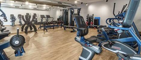 Et fitnesscenter med forskellig træningsudstyr, herunder løbebånd og styrkemaskiner.