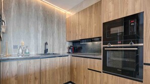 Une cuisine moderne avec des meubles en bois, un four double et un plan de travail en acier inoxydable.