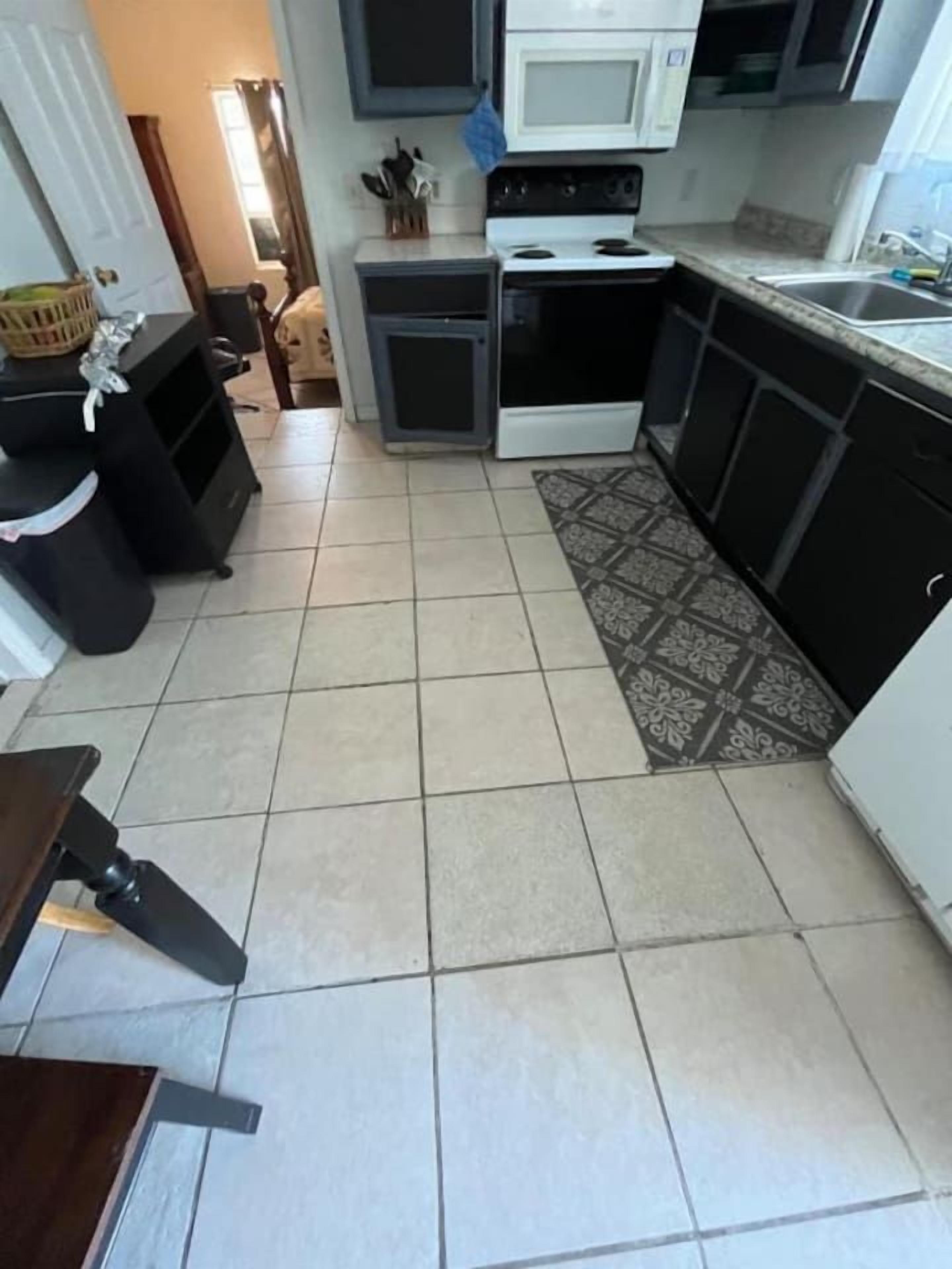 A kitchen with a stove, microwave, and sink.