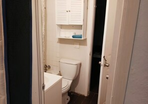 A small bathroom with a toilet, a sink, and a cabinet above the toilet.