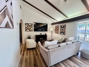 Ein Wohnzimmer mit einer Couch, einem Fernseher und Wanddekoration.