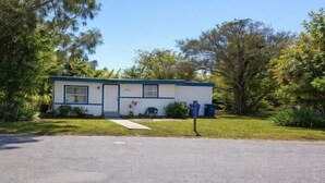 A single-story building with a front door, windows, and a small porch area.