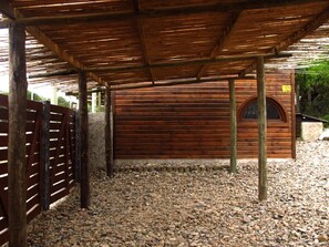 A covered outdoor area with a wooden floor, a wooden fence, and a building with a wooden door. - Tiny beach cabin with an ocean view (Rocha)