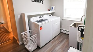 Un cuarto de lavandería con lavadora, secadora y un letrero en la pared que dice 'Laundry'.
