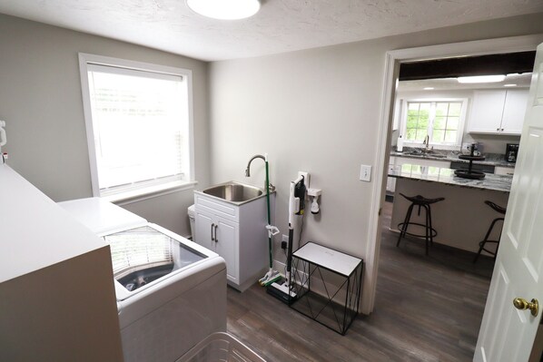 A compact kitchen with a built-in dishwasher, a sink, and a small table.