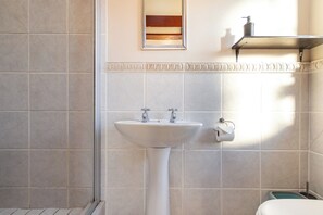 A bathroom with a pedestal sink, a toilet, and a towel rack. - Coastal stay in safest neighbourhood. (Cape Town)