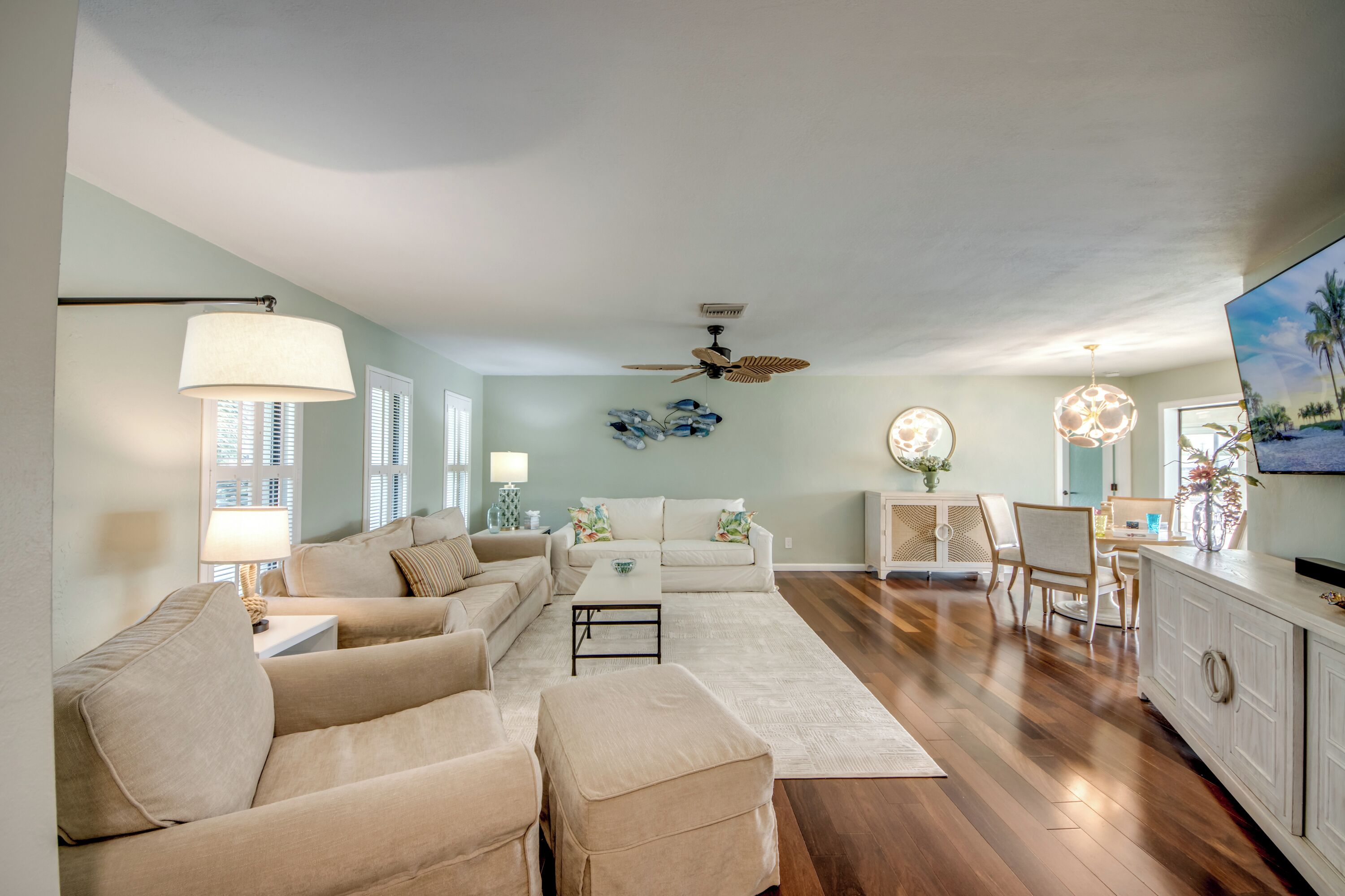 A spacious living area with a sofa set, a coffee table, and a dining area with chairs and a table.
