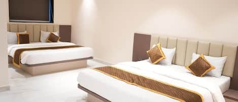 A hotel room with two beds, a large window, and a flat-screen TV.