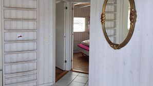 A room with a bed, a mirror, and a door leading to another room. - 4 Star Holiday Home in Hejls (Hejls)