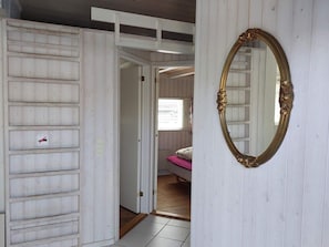 A room with a bed, a mirror, and a door leading to another room. - 4 Star Holiday Home in Hejls (Hejls)