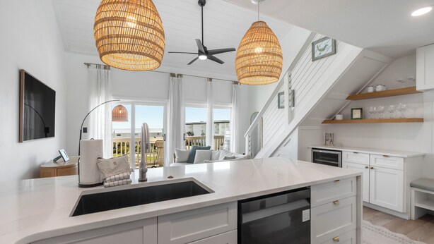 A modern kitchen with a large island, white cabinetry, and a built-in dishwasher. - Salt Haus 30A: Pet Friendly Gulf View Loft (Santa Rosa Beach)