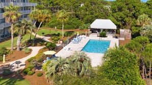 A resort with a swimming pool, lounge chairs, and a covered patio area. - Salt Haus 30A: Pet Friendly Gulf View Loft (Santa Rosa Beach)
