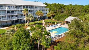 A hotel with a pool, multiple balconies, and lush greenery. - Salt Haus 30A: Pet Friendly Gulf View Loft (Santa Rosa Beach)
