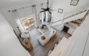 Ein geräumiger Wohnbereich mit einer Couch, einem Couchtisch und einem Deckenventilator.