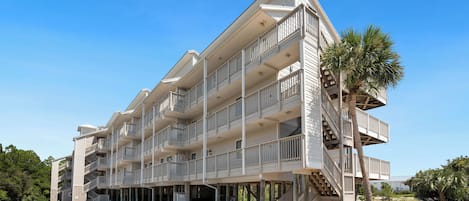 A multi-story hotel with balconies and a covered outdoor area.