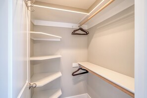 Armadio a muro con scaffali bianchi e ante in legno.
