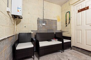 A room with two wicker chairs, a white door, and a wall-mounted electrical box. - Applin House|5BR Contractor Stay|Parking WiFi (Bristol)