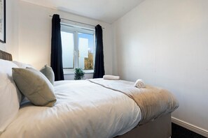 A bedroom with a bed, pillows, a window with curtains, and a plant. - Applin House|5BR Contractor Stay|Parking WiFi (Bristol)