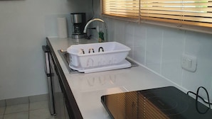 A kitchen with a microwave, coffee maker, and a sink. - Marina Loft #103, 1 Floor (Sardinal)