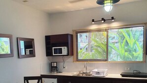 A compact kitchen with a dining area, equipped with a microwave, a coffee maker, and a sink. - Marina Loft #103, 1 Floor (Sardinal)