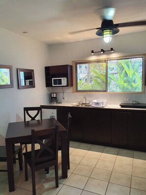 A compact kitchen with a dining area, equipped with a microwave, a coffee maker, and a sink. - Marina Loft #103, 1 Floor (Sardinal)