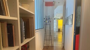 A hallway with wooden flooring, white shelving units, and a coat rack with colorful balls. - Spacious 170 m² Loft – 3 Bedrooms – Canal St-Martin – Fully Furnished & Designer (Paris)