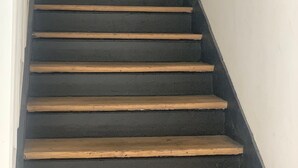A staircase with dark steps and a handrail, leading upwards. - Spacious 170 m² Loft – 3 Bedrooms – Canal St-Martin – Fully Furnished & Designer (Paris)