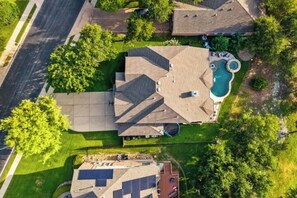 Een woonwijk met een huis, een zwembad, een garage en een verzorgd gazon.