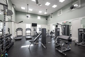 Ein Fitnessstudio mit Laufbändern, Kraftgeräten und Kurzhanteln.