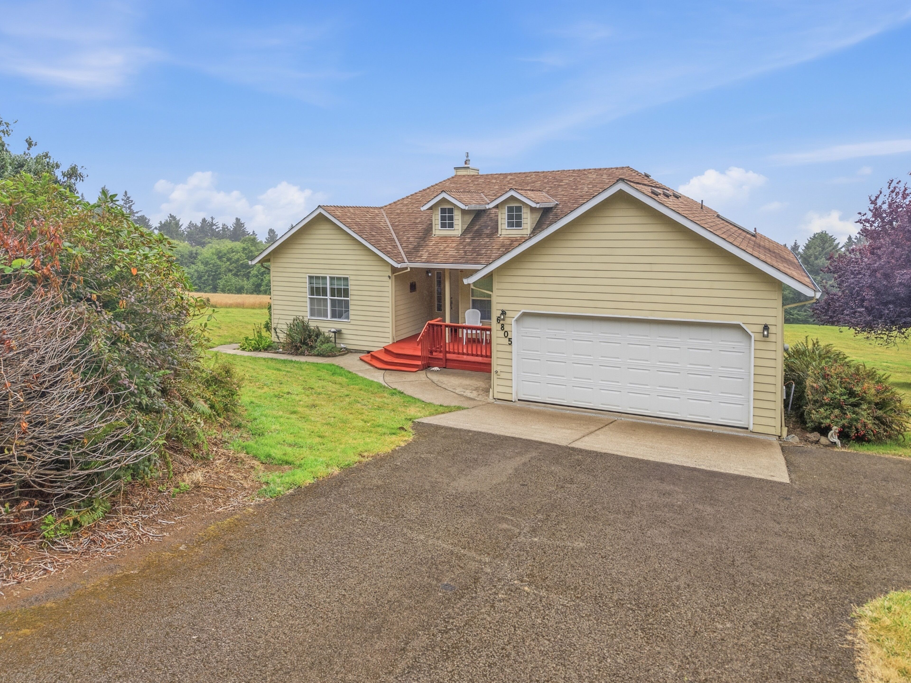 A single-story house with a red front porch, a garage, and a well-maintained lawn.