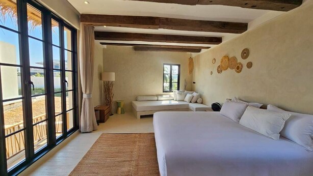 Un dormitorio con una cama grande, un sofá y una ventana con vistas.