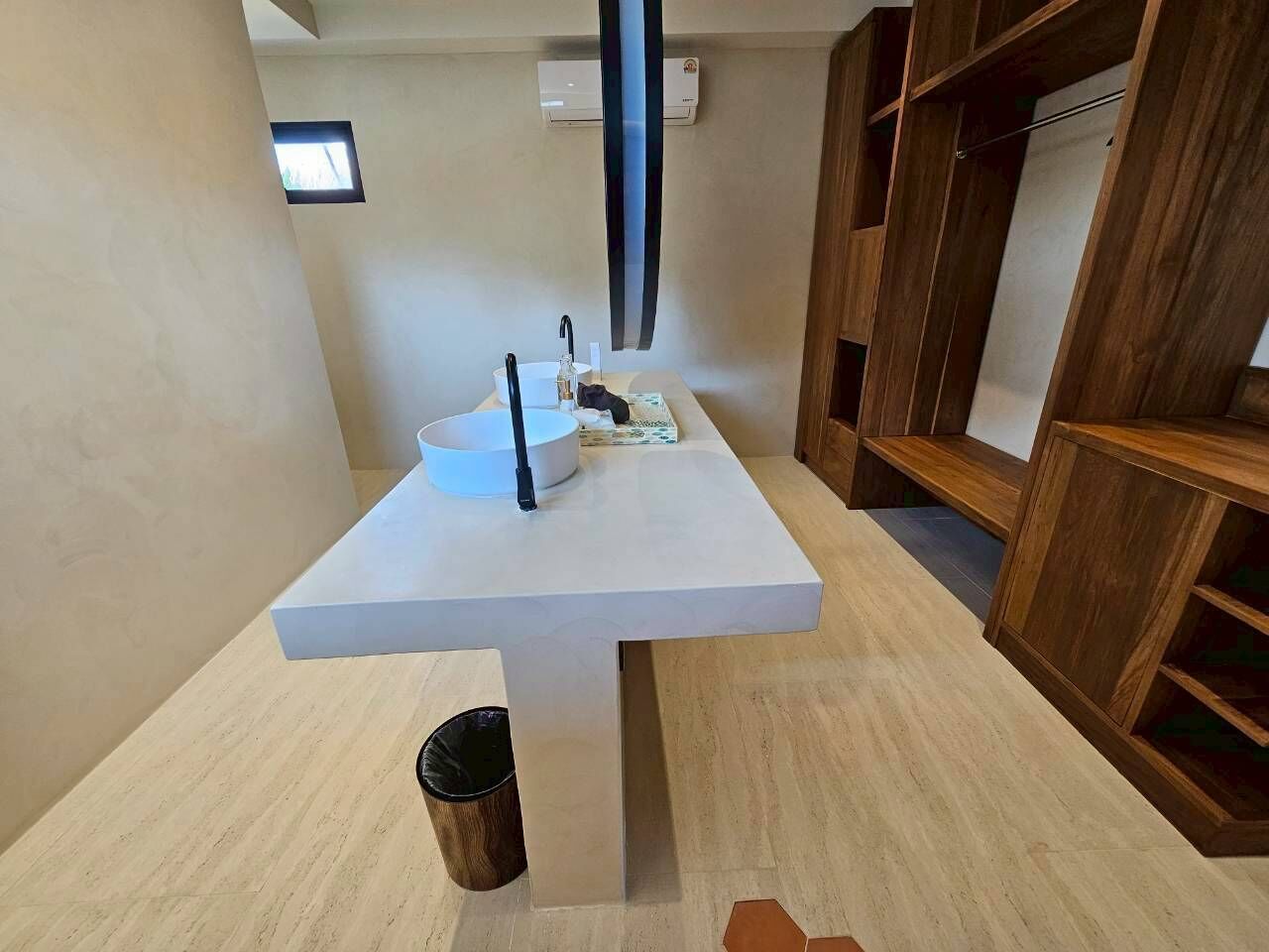 A modern bathroom with a white sink, a mirror, and a towel rack.