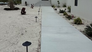 A modern two-story house with a concrete pathway leading to the entrance. - Spectacular Beachfront Ultra Luxury Villa Stella Maris-Introductory Sale! (Sandy Point)