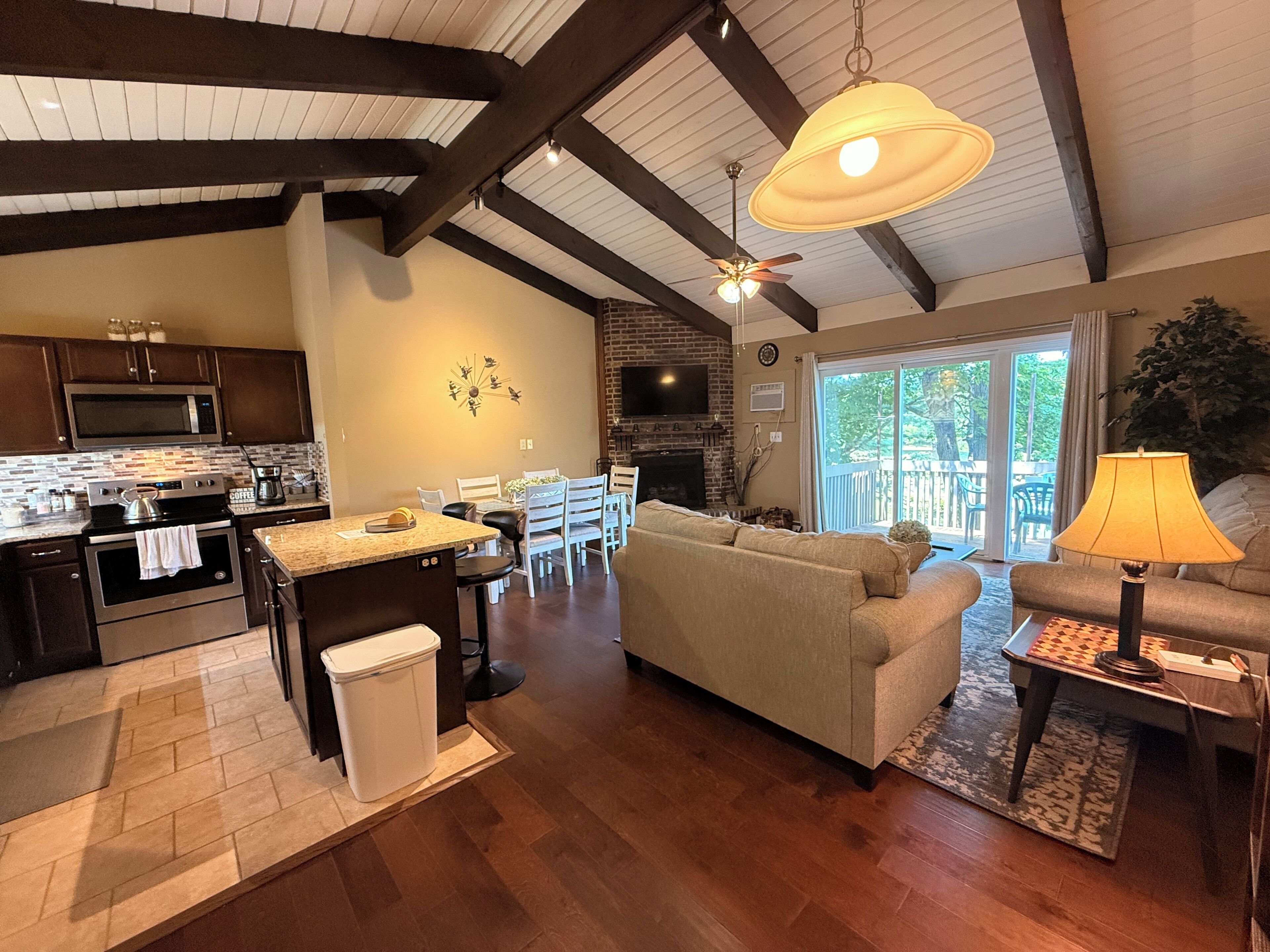 A modern kitchen with built-in appliances, a dining area with a large window, and a cozy living room with a fireplace.