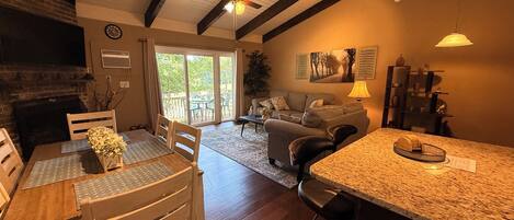 A spacious living area with a dining table, chairs, a sofa, and a kitchen island.