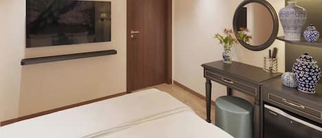 A hotel room with a bed, bedside table, dresser, mirror, and wall-mounted artwork.