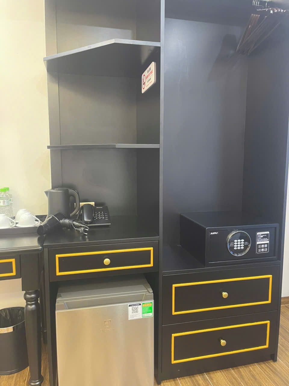 Una kitchenette equipada con microondas, cafetera y refrigerador pequeño.