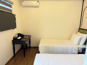 A small, clean room with two beds, a desk with a chair, and an air conditioning unit on the wall. - Alley Garden Hotel & Spa (Hanoi)