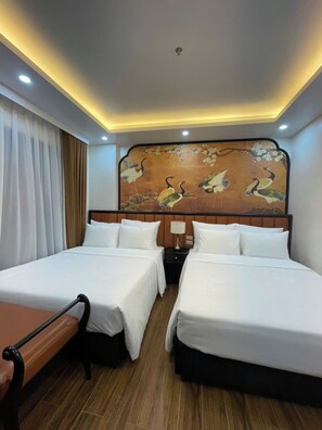 A hotel room with two beds, a wooden headboard with a painting, a nightstand, and a bench. - Alley Garden Hotel & Spa (Hanoi)