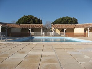 A swimming pool with a tiled deck, surrounded by covered seating areas with a tiled roof. - Vacation in Portiragne-Plage (Portiragnes)