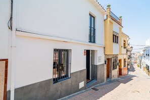 A narrow street with buildings featuring balconies and windows, some with metal bars. - Cubo's Coin Center Terrace House / urban / close to shops / free wifi (Coín)