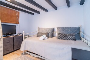 A bedroom with a bed, bedside tables, a television, and a radiator. - Cubo's Coin Center Terrace House / urban / close to shops / free wifi (Coín)