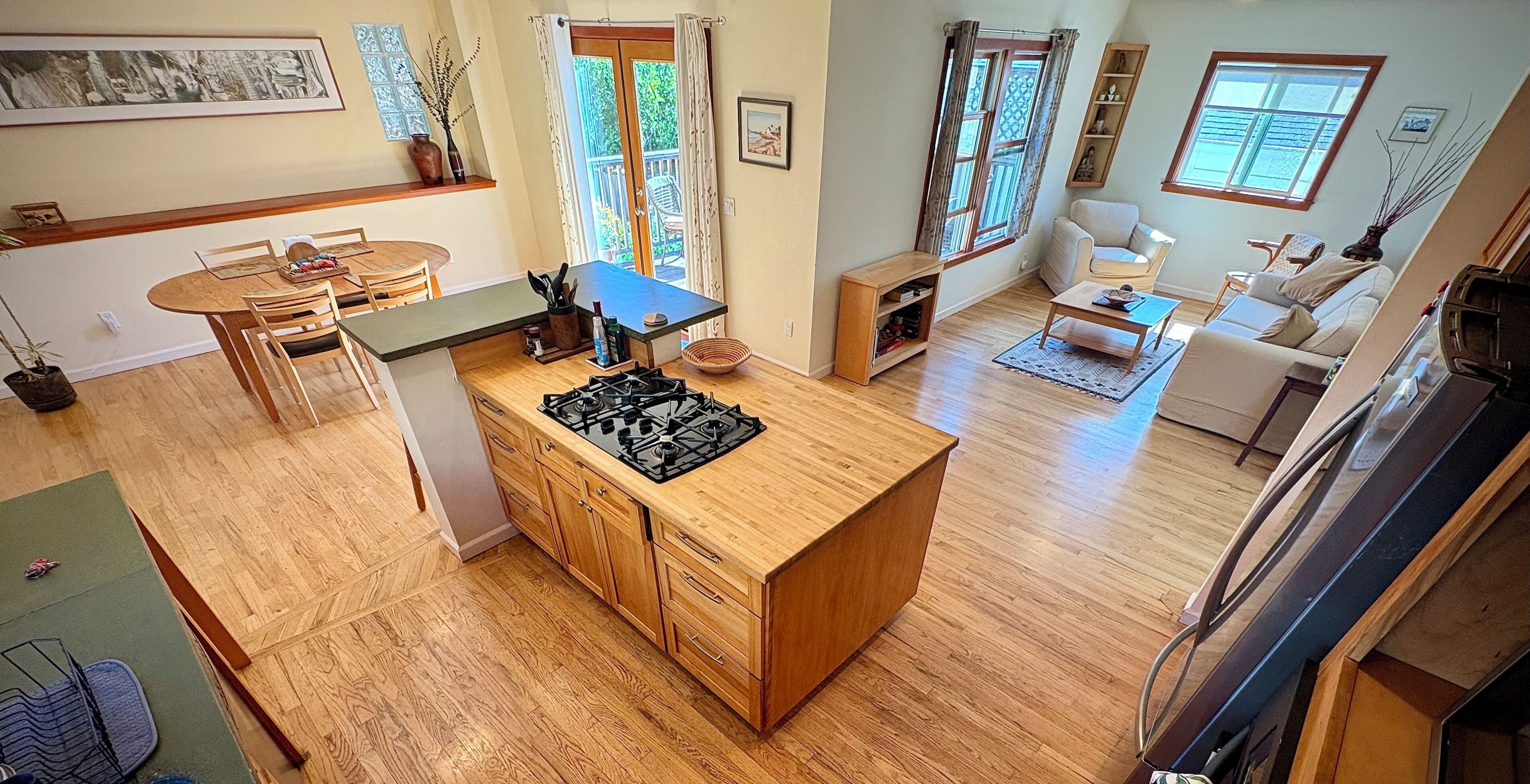 A spacious living area with a kitchen island, dining table, and seating arrangements.