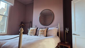 A bedroom with a bed, a bedside table, a mirror, and a window. - Luxury Sea View Historic Apartment (Ramsgate)